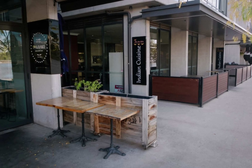 An empty cafe and restaurant in Canberra, their tables pushed to the side and stacked away.