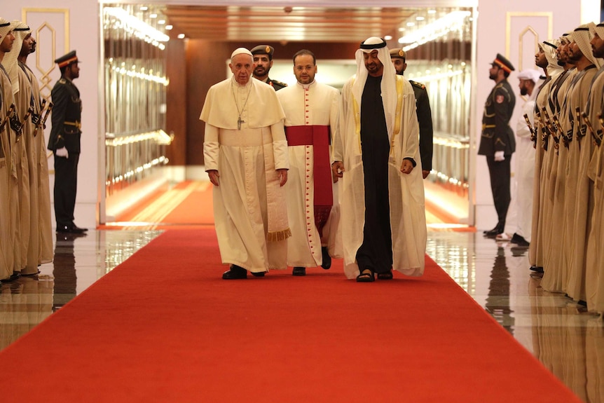 Pope Francis is welcomed by Abu Dhabi's Crown Prince Sheikh Mohammed bin Zayed Al Nahyan surrounded by guards at the airport.