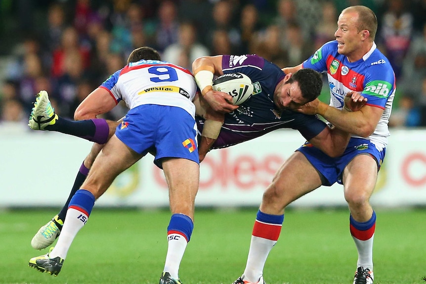 Torrid affair ... Bryan Norrie is tackled by Danny Buderus (L) and Beau Scott