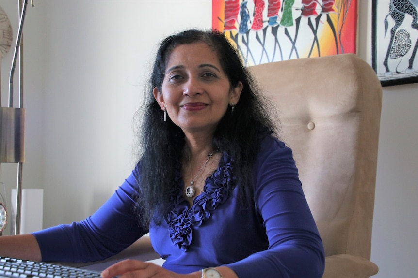 Professor Jaya Dantas sitting at the computer in her home office. 