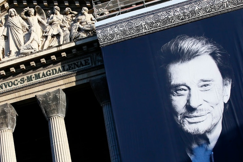 A giant black and white poster of Johnny Hallyday hangs on the facade of the Madeleine church in Paris
