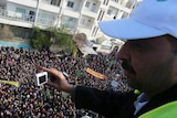 An Arab League observer takes photos for anti-government protesters on the streets in Adlb in Syria.