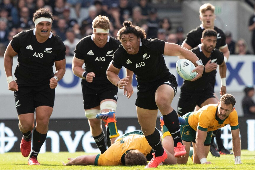 A New Zealand All Blacks player makes a break against the Wallabies.