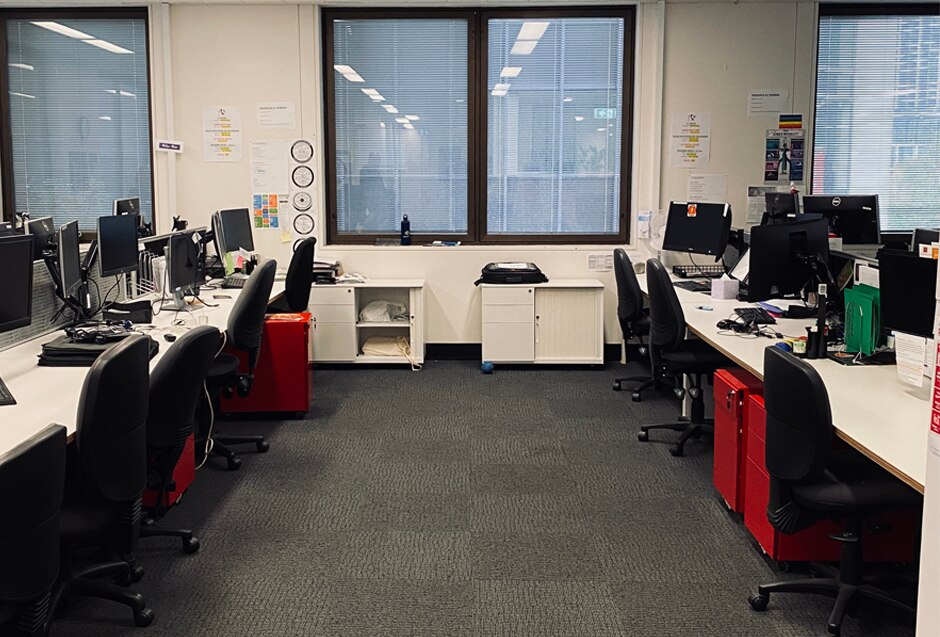 An office space full of desks and red filing cabinets