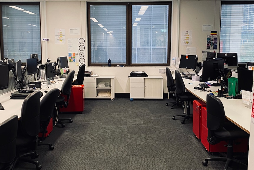 An office space full of desks and red filing cabinets