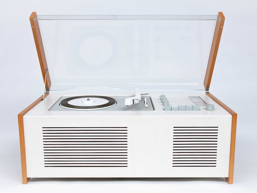 A white turntable with its plexiglass lid open.