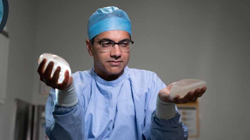 Professor Anand Deva examines two different types of breast implant, a smooth version and a textured model.
