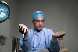 Professor Anand Deva examines two different types of breast implant, a smooth version and a textured model.