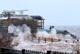 Huge waves smash waterfront homes.