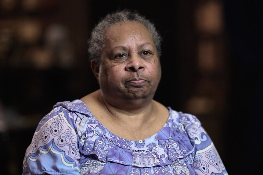 Indigenous woman wearing a light blue dress. 