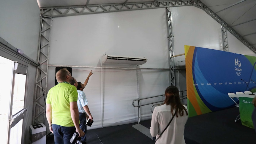 Venue staff inspect bullet hole in media tent
