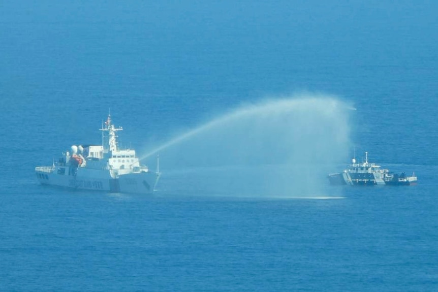 2023年12月9日星期六，一艘中国海警船（左）在接近有争议的南中国海黄岩岛（又称斯卡伯勒浅滩）时向一艘菲律宾渔业和水产资源局船只使用水炮。