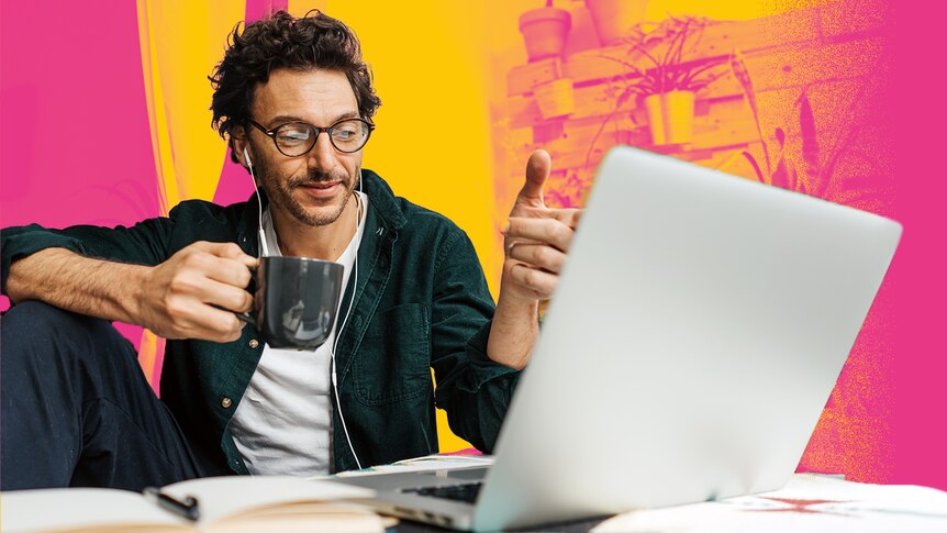 Man sits at laptop while drinking from a mug