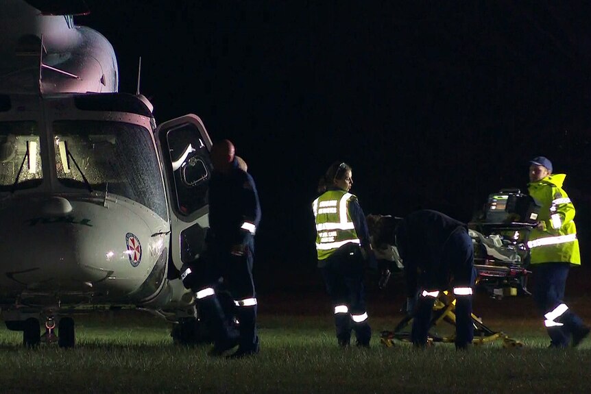 ambulance workers taking a patient to the rescue helicopter after a crash in the bayview suburb of sydney