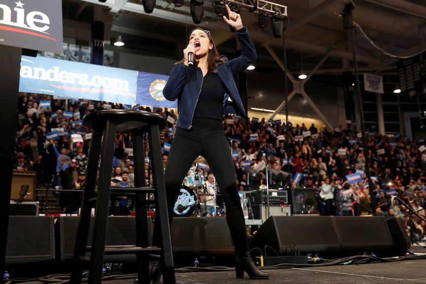 US Representative Alexandria Ocasio Cortez hypes up a crowd while campaigning for Senator Bernie Sanders