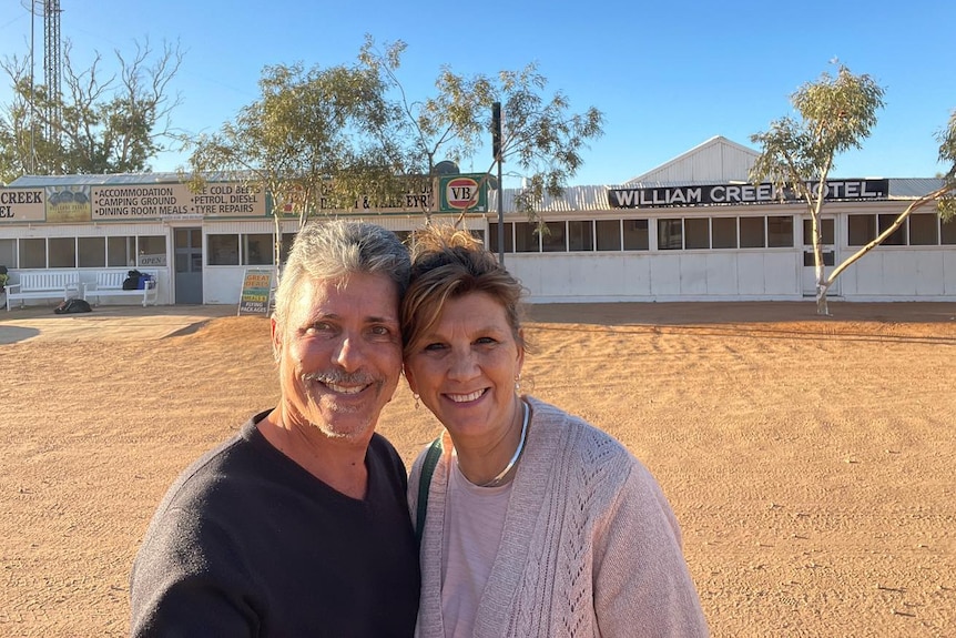 Man and woman in front of William Creek hotel building 