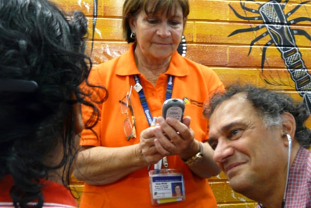 A doctor and a nurse talking to a patient whose face is not visible