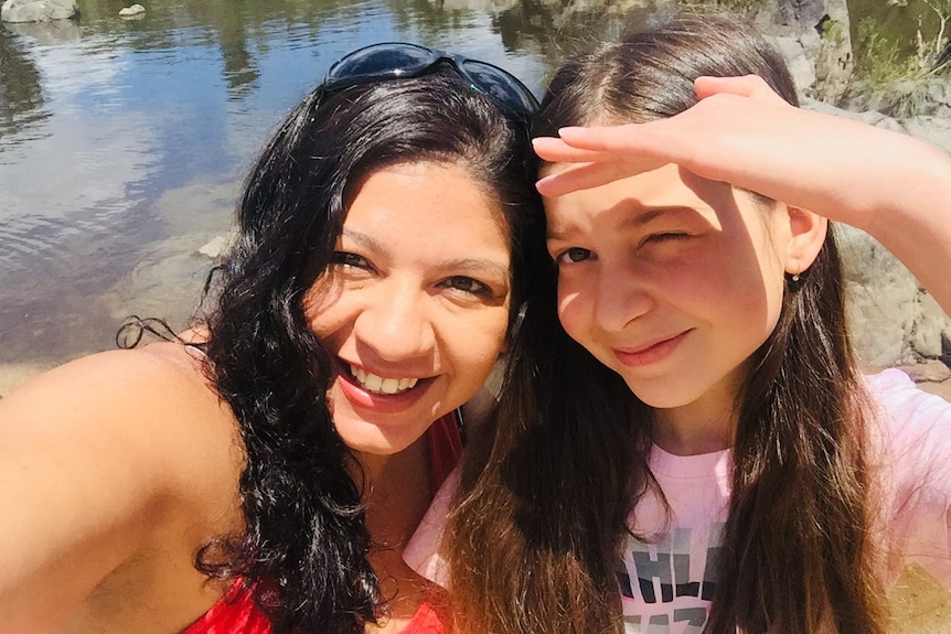 selfie of woman with daughteer near a lake