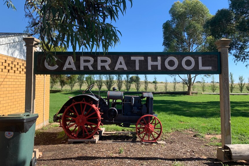 An old tractor beneath a sign that says "Carrathool".