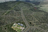 An artist's rendering shows an aerial shot of buildings and roads overlaid on hills and bushland.