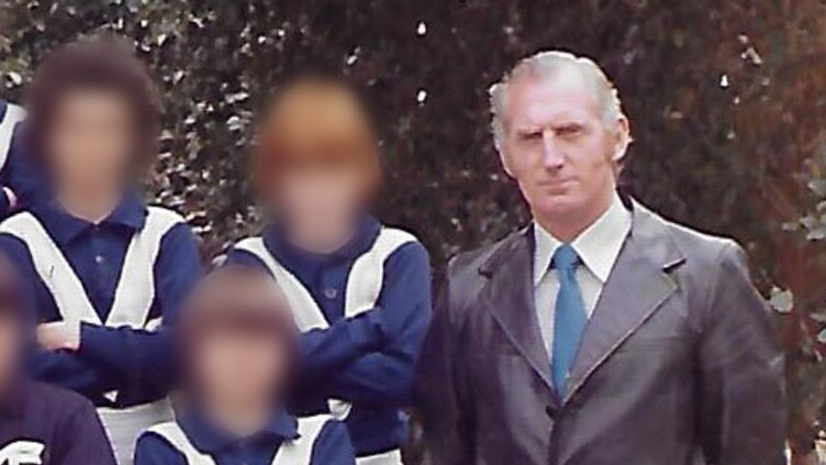 An old colour photo of a man posing with a football team of boys. The boys' faces are blurred.
