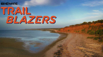 The sea is seen to the left with a cliff face on the right. A Trailblazer logo is seen on the left.
