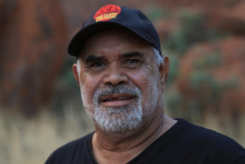 Indigenous man wearing a black shirt and black cap.