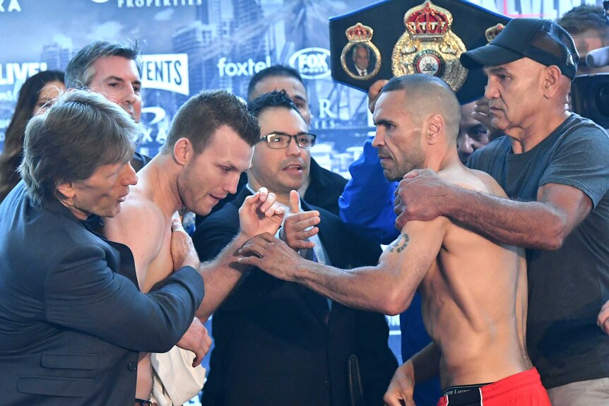 Jeff Horn and Anthony Mundine are held back from each other during their weigh-in.