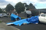 The wreckage of a plane crash covered in blue tarps on Scarlet Street in Mordialloc.