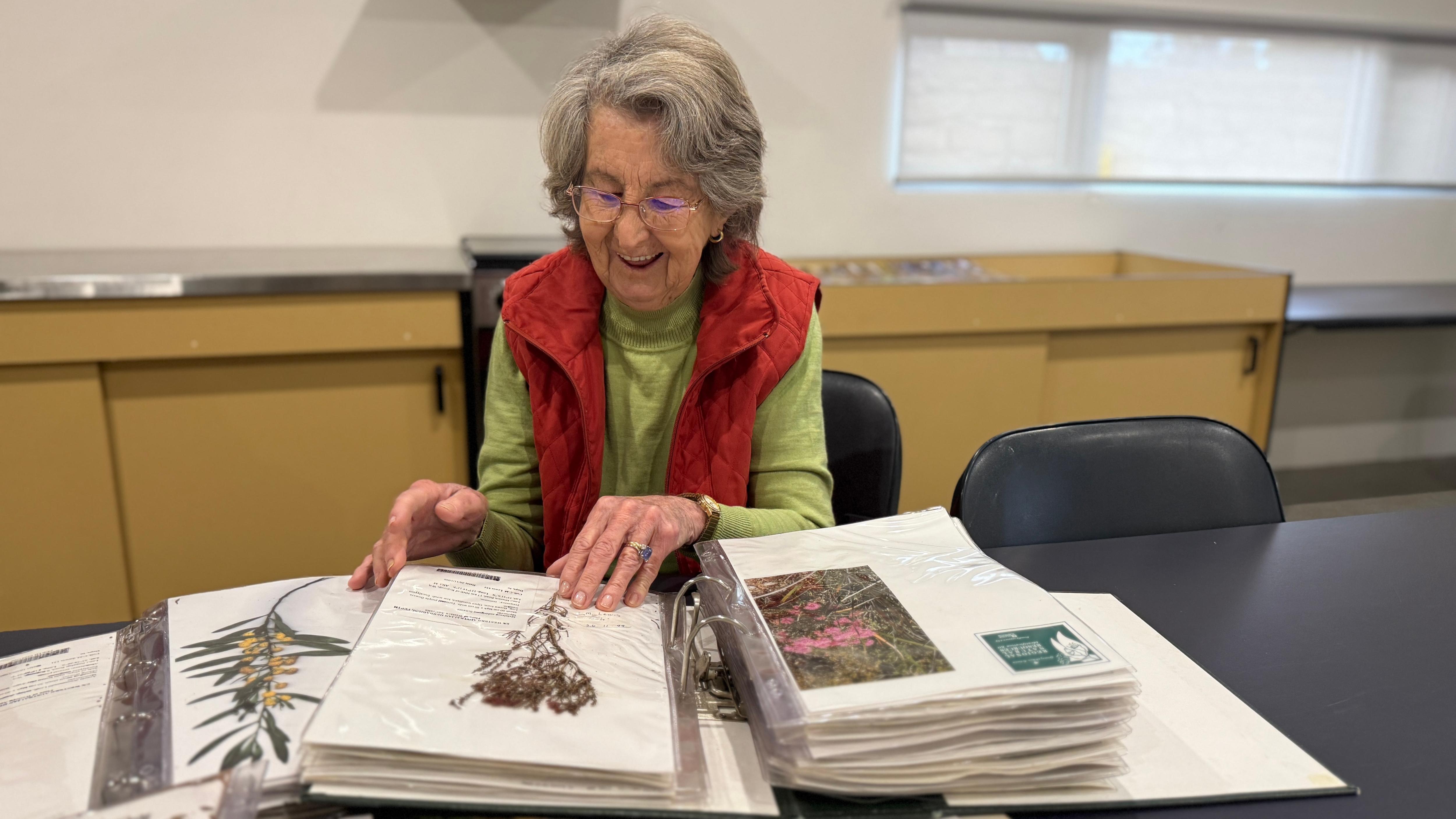 A medium shot of a woman looking at books