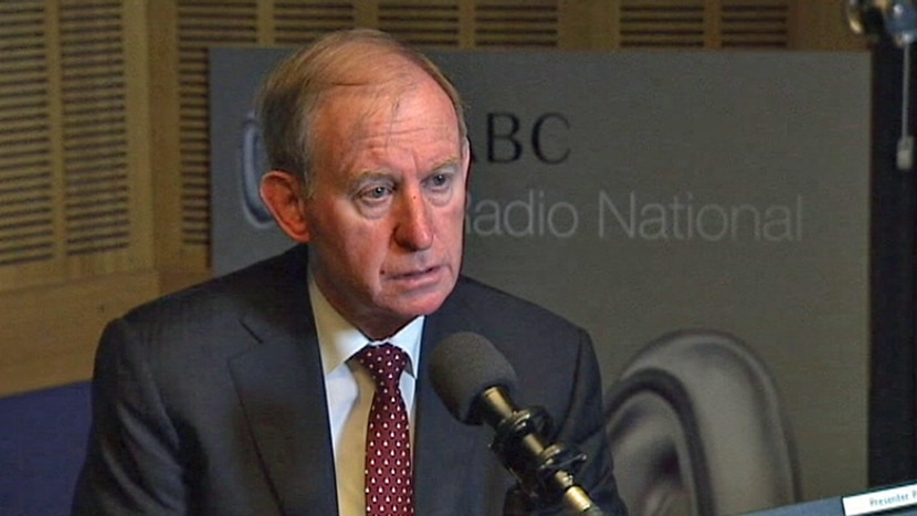 David Murray sits at a microphone in front of an ABC Radio National sign