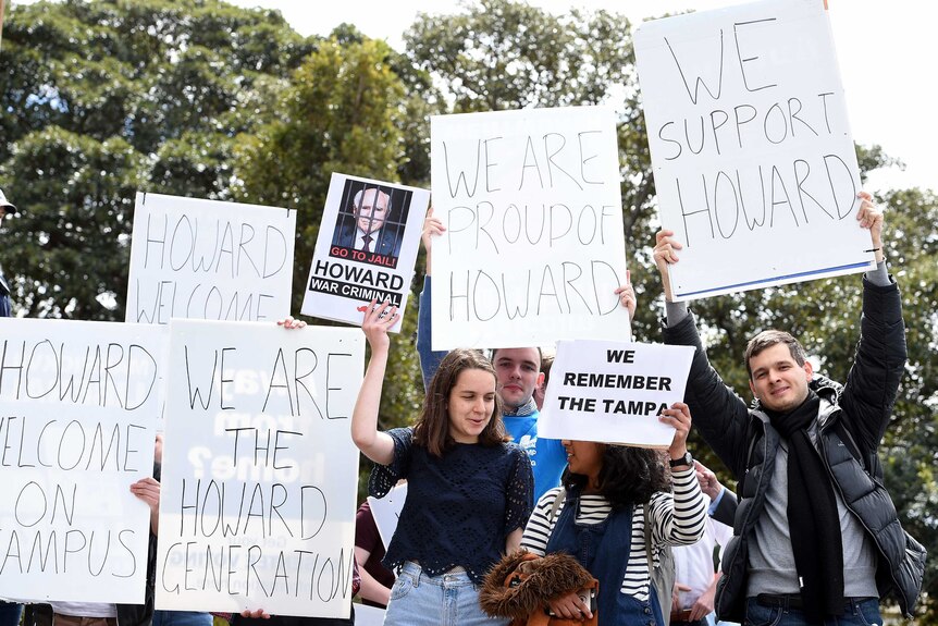 People hold up for and against signs.