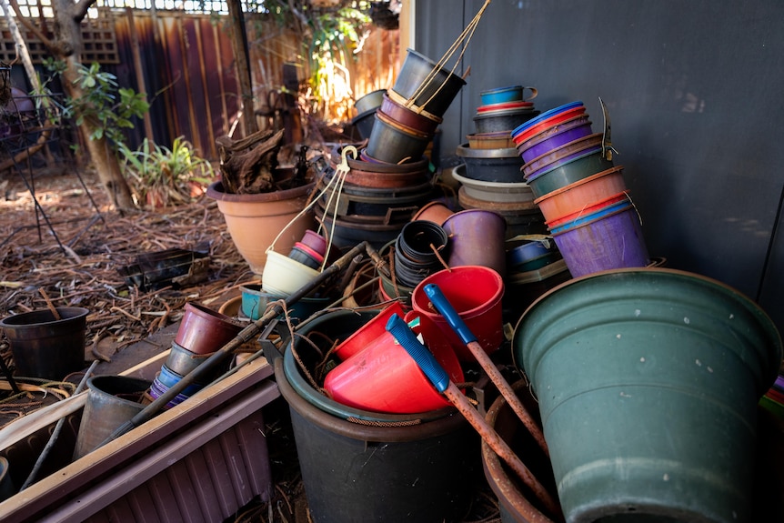 A clutter of different sized and coloured plastic gardening pots.