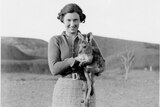Black and white image of woman holding joey