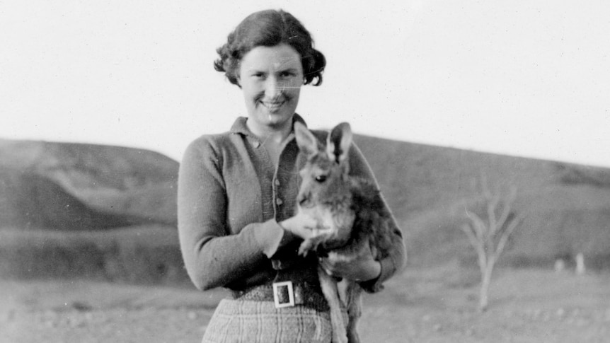 Black and white image of woman holding joey