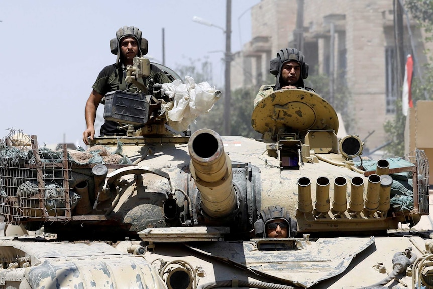 Iraqi soldiers look out from a tank as they advance towards Islamic State positions in Mosul.