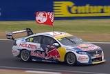 A large Holden flag flies out the side of Shane van Gisbergen's car at Bathurst.