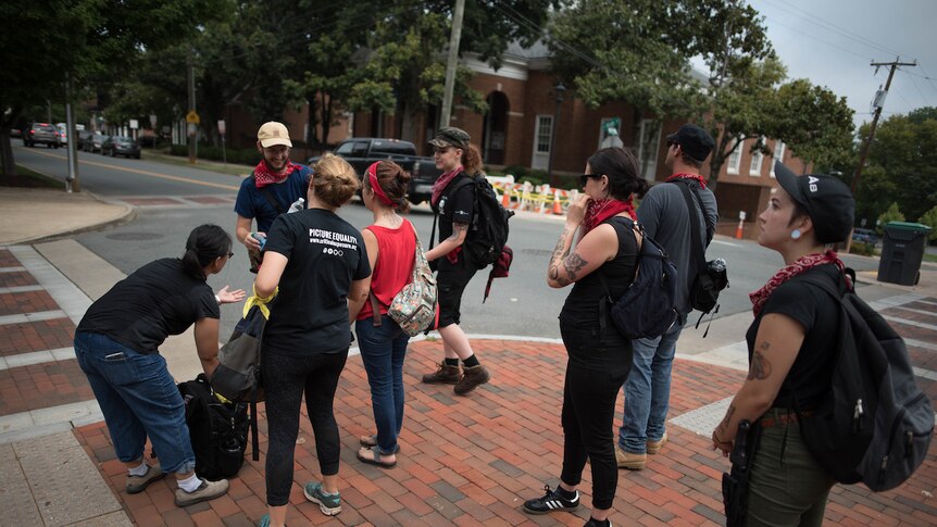 Redneck Revolt members stand at a street corner in Charlottesville.