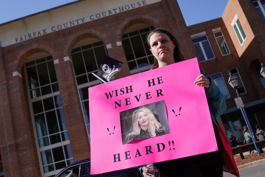 Woman with anti-Heard sign outside court