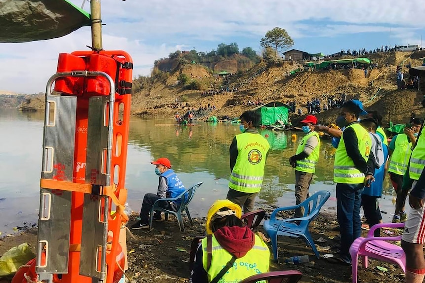 People wait for rescuers to finish their search of a jade mining area