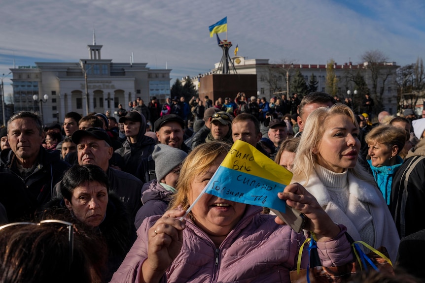 Residents celebrating and holding Ukrainian flags. 