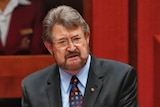 Derryn Hinch wears a colourful tie and black suit in Parliament.