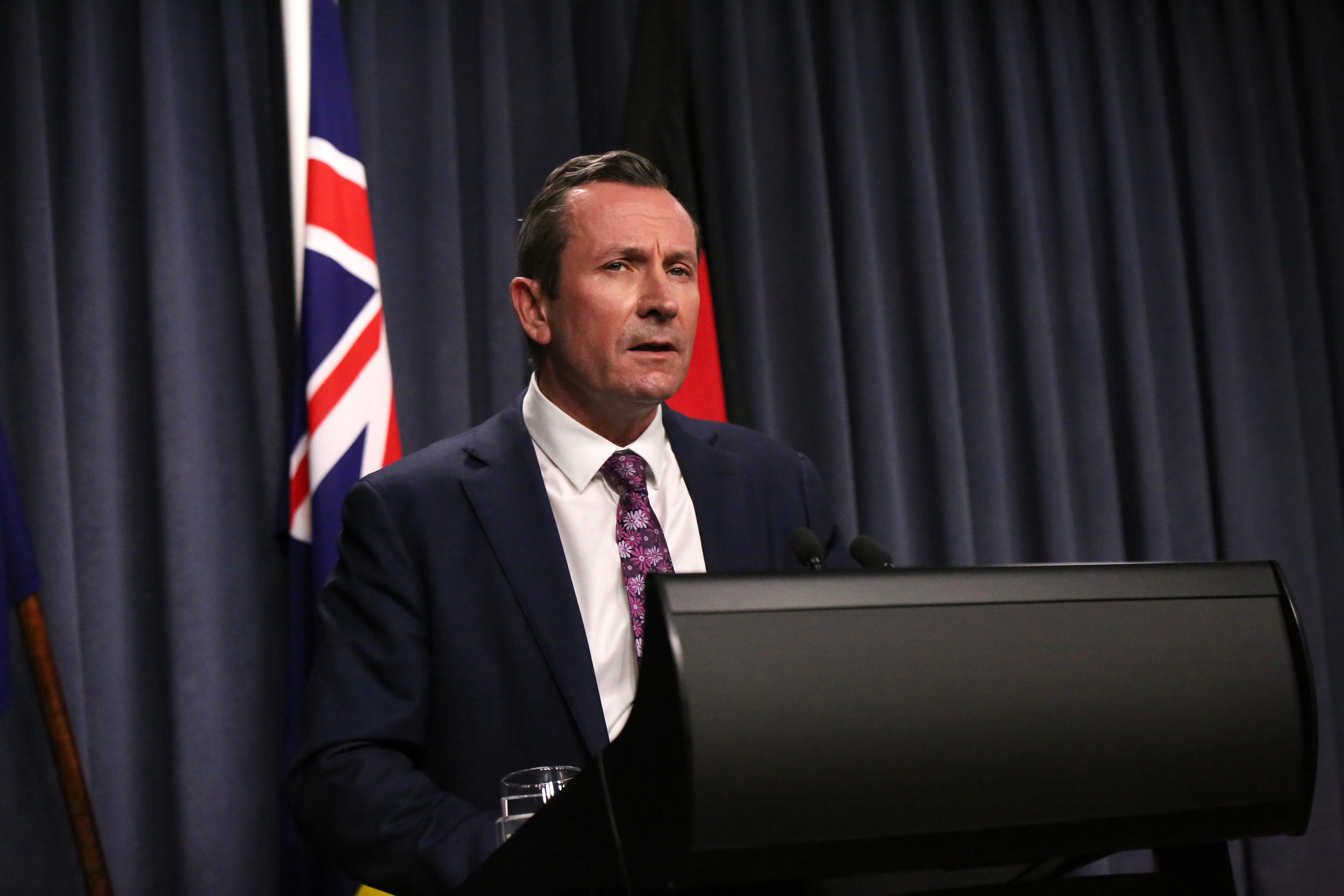 西澳州长 Mark McGowan 穿着西装打领带在室内媒体会议上发表讲话。 