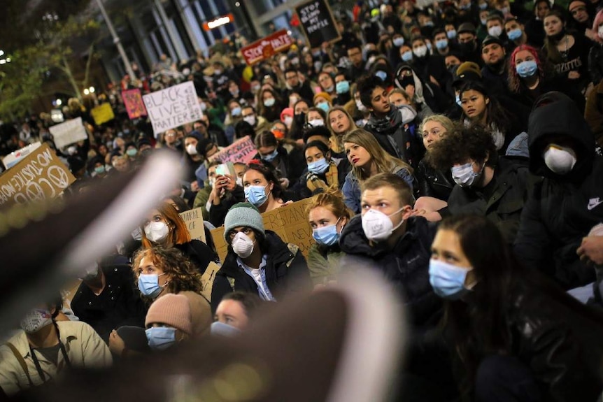 Protesters carry signs