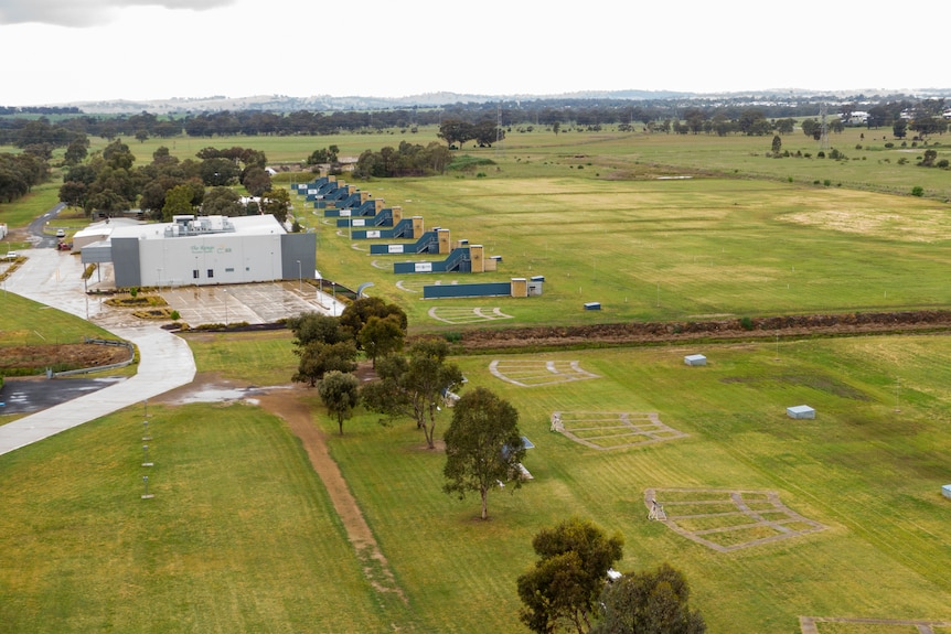 Aerial photo of green fields with buildings on the edge.