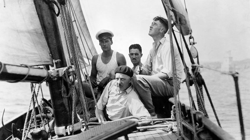 Four men on a sail boat black and white. 
