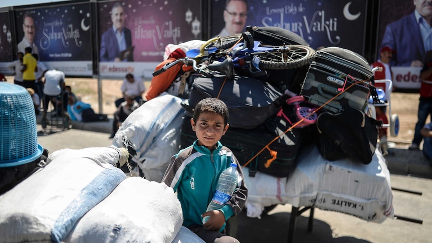 A young boy waits to return home to Tal Abyad on Wednesday.