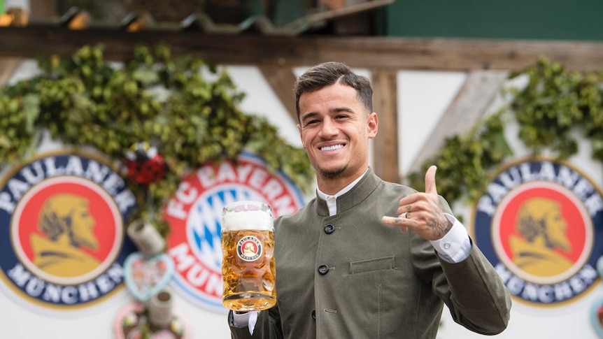 Bayern Munich player Philippe Coutinho poses with a beer.