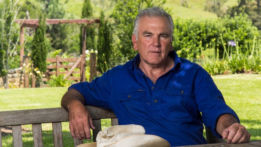 Noel Brown sits at a table in his backyard.