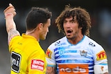 An NRL referee points with the index finger on his left hand as he sends off a Gold Coast Titans player.